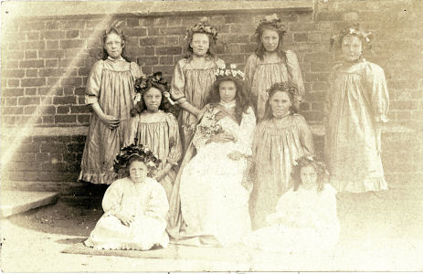 Girls from Boxmoor School, Hemel Hempstead, dressed with floral hats and the May Queen?